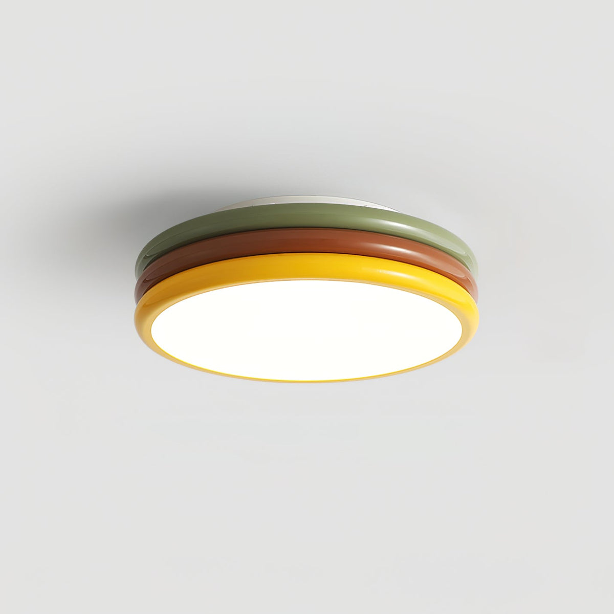 Simple side view of this Clérachic ceiling light on a grey backdrop, with green, red-brown and yellow tiers and the diffuser lit.