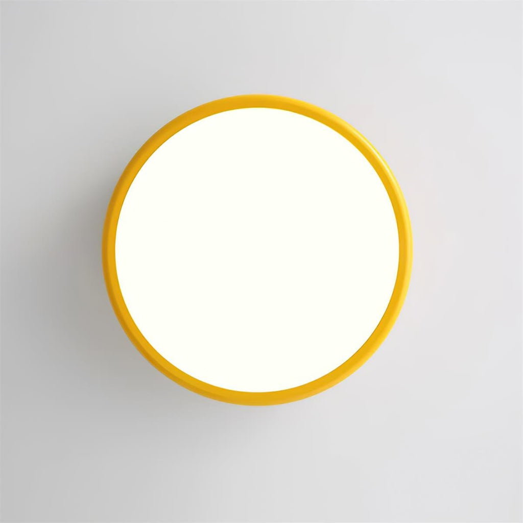 Looking straight up at the lit round diffuser and yellow outer ring of this Clérachic ceiling light on a grey ceiling.
