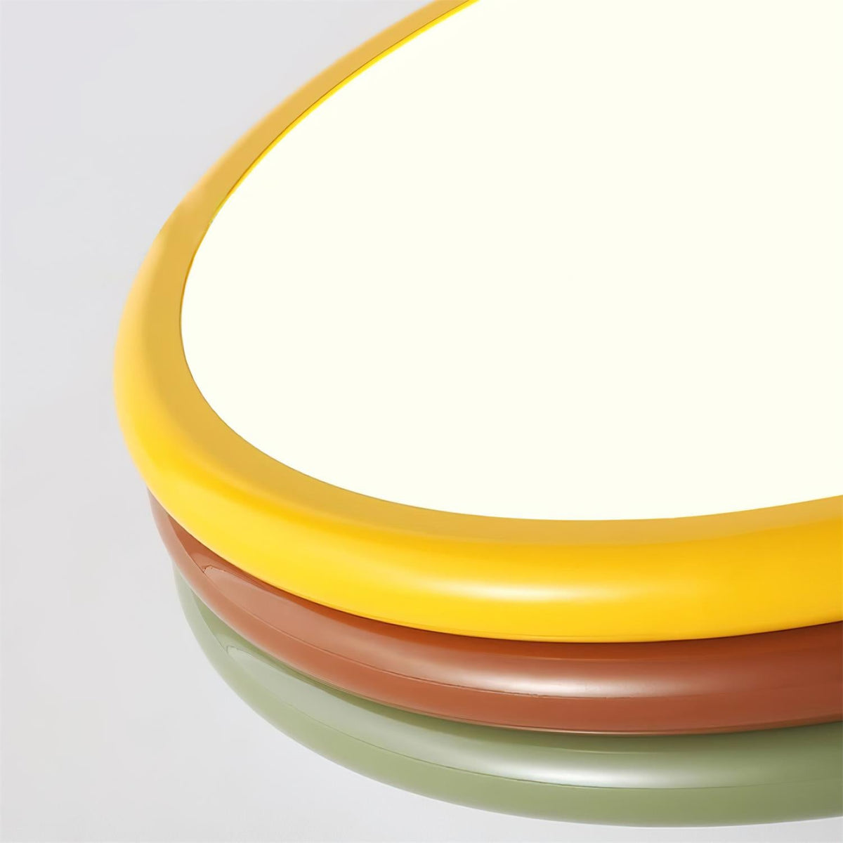 Close crop of the yellow, red-brown and green rings along one side of this Clérachic ceiling light, with the diffuser lit.