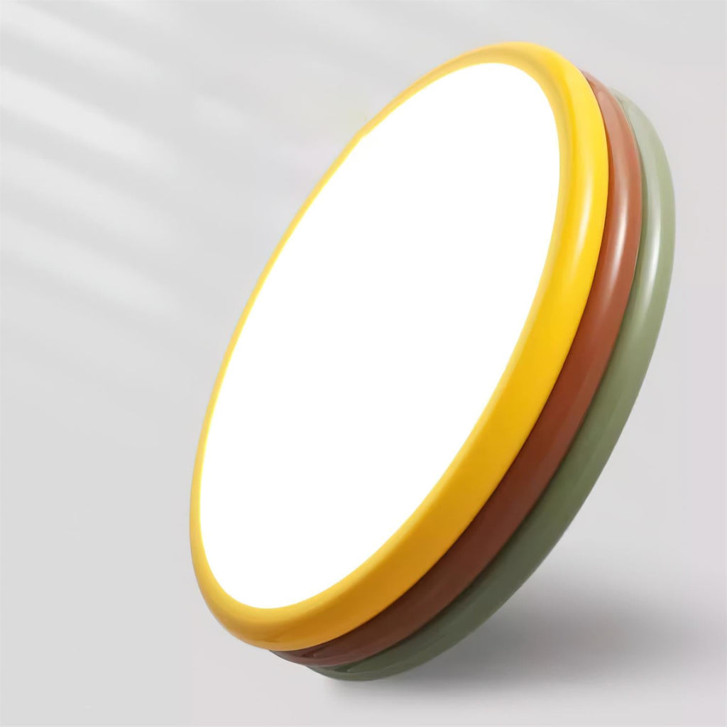 This Clérachic ceiling light tilted on its side to show the yellow, red-brown and green rings behind its bright round face.