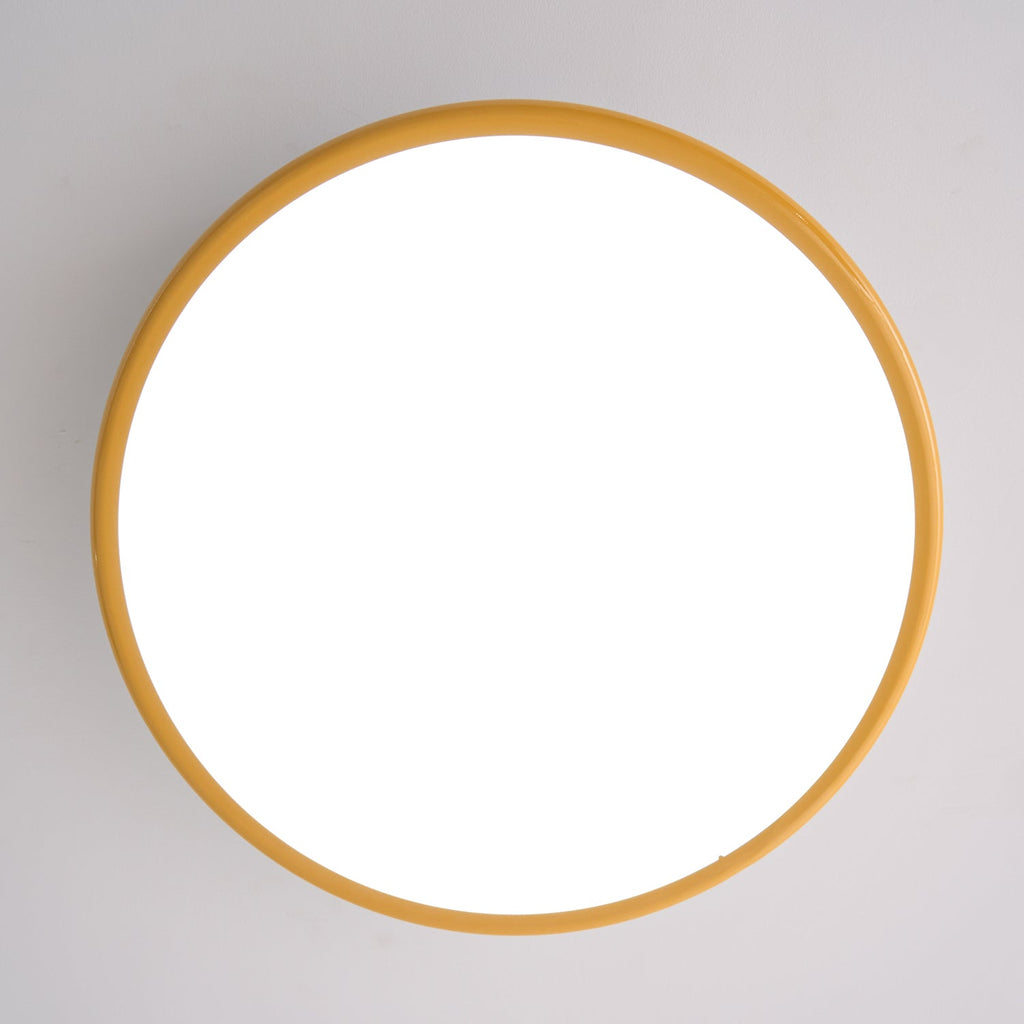 Straight-on view of this Clérachic ceiling light switched on, its diffuser fully lit inside a thin golden-yellow ring.