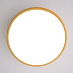 Straight-on view of this Clérachic ceiling light switched on, its diffuser fully lit inside a thin golden-yellow ring.