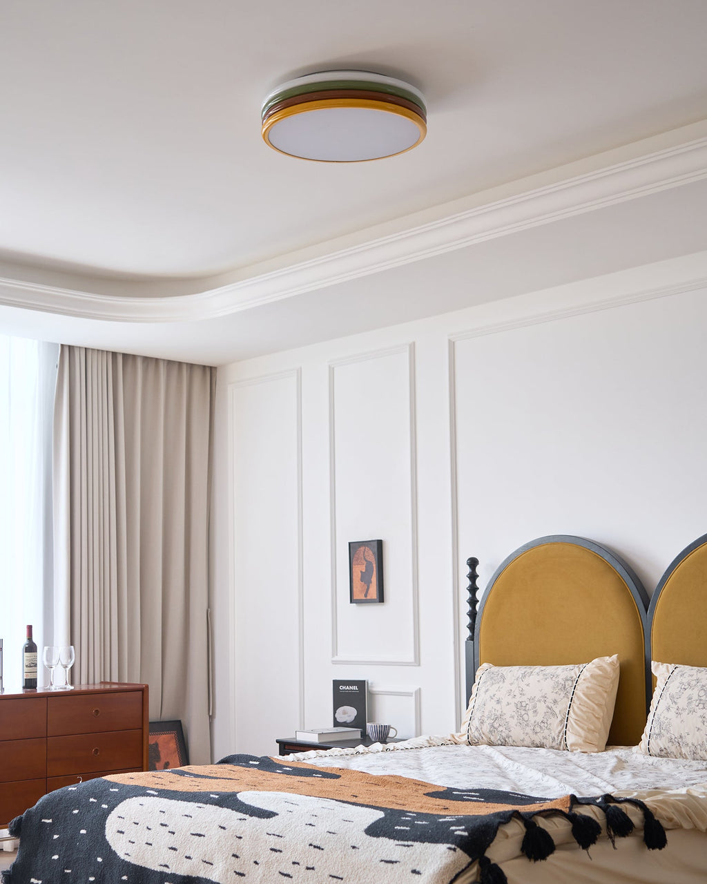Unlit Clérachic ceiling light above the same bedroom, with a stepped white cornice and beige curtains at the window.
