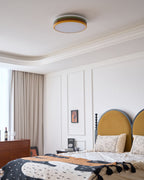 Unlit Clérachic ceiling light above the same bedroom, with a stepped white cornice and beige curtains at the window.