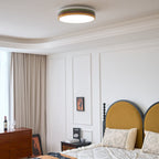 Lit Clérachic ceiling light above a bed with a mustard arched headboard, framed art and a wood bedside table.