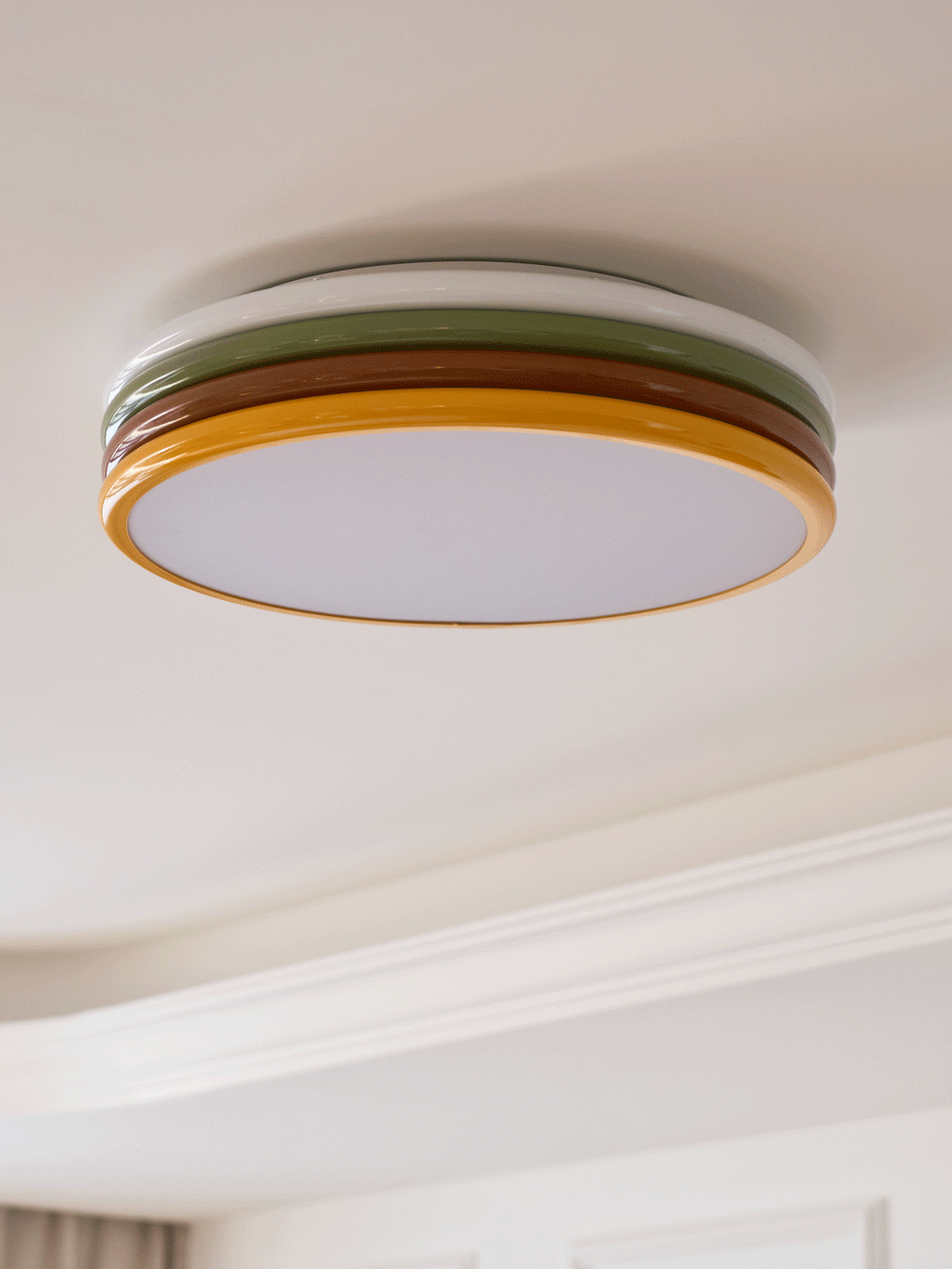 Unlit Clérachic ceiling light on a pale ceiling beside a white cornice, with its frosted diffuser facing down.