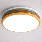 Underside of this lit Clérachic ceiling light, a bright round diffuser inside a golden-yellow ring and the layered tiers above.