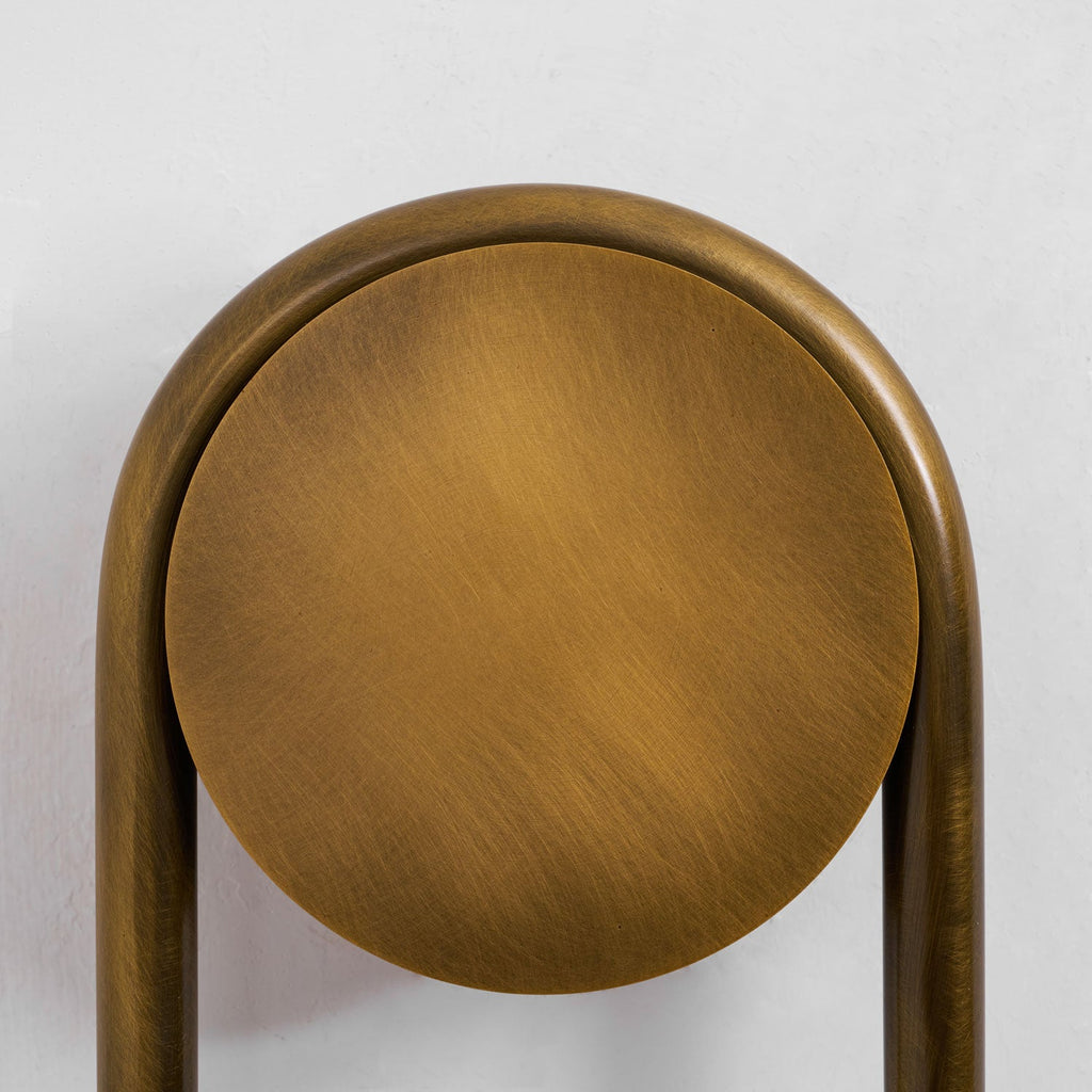 Close view of the brushed antique-brass backplate and arch on this Clérachic sconce.