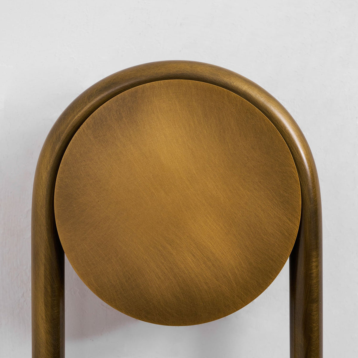 Close view of the brushed antique-brass backplate and arch on this Clérachic sconce.