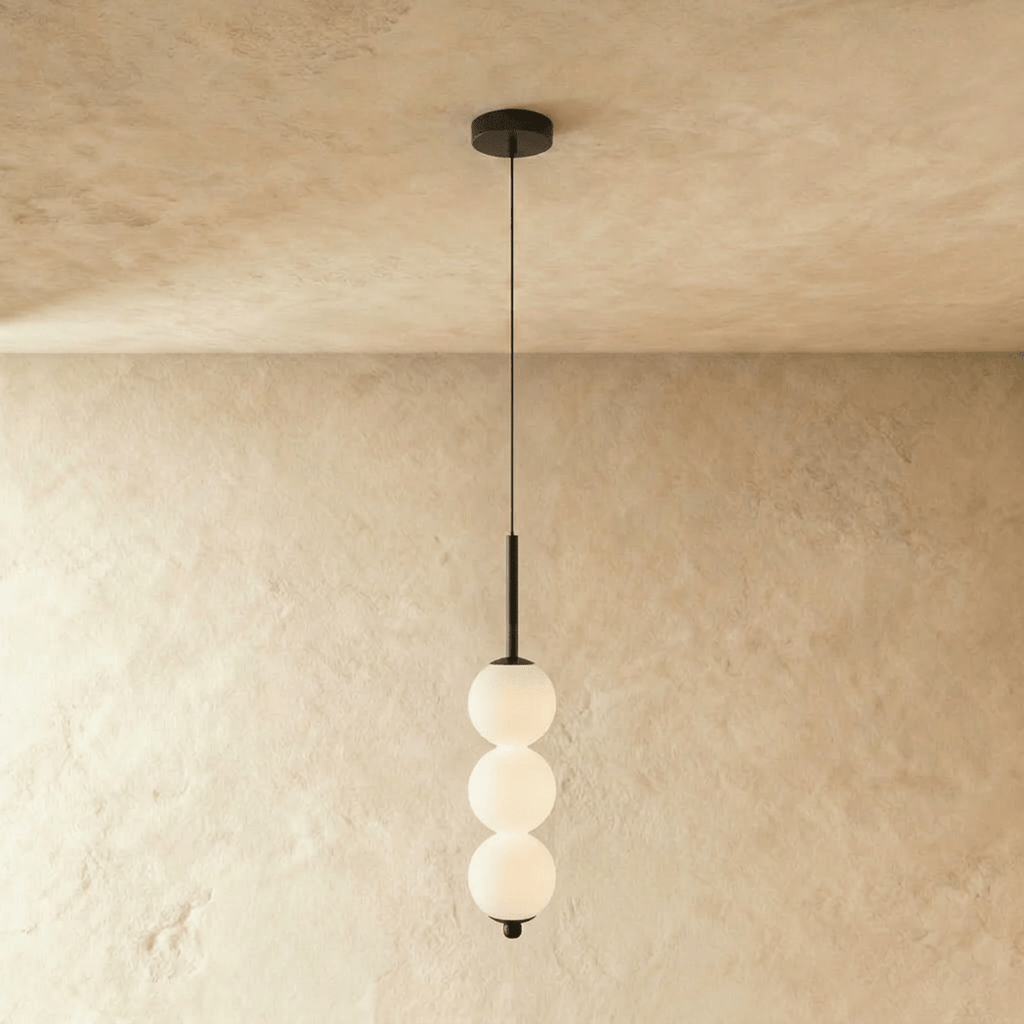 Clérachic three-ball pendant in black with glowing opal glass spheres, hung from a round ceiling canopy.