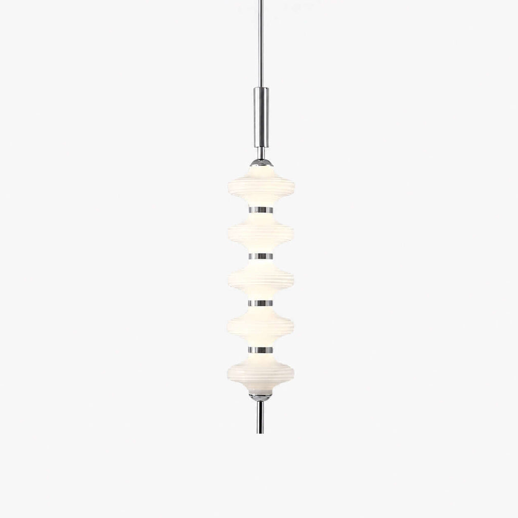 Chrome and white Clérachic pendant of five stacked ribbed glass discs on a slim rod, lit and hung on a plain white backdrop.