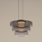 Close view of the three-tier Smoke Gray Clérachic Stacked Glass Disc Pendant Light, a rolled bead catching light on every rim.