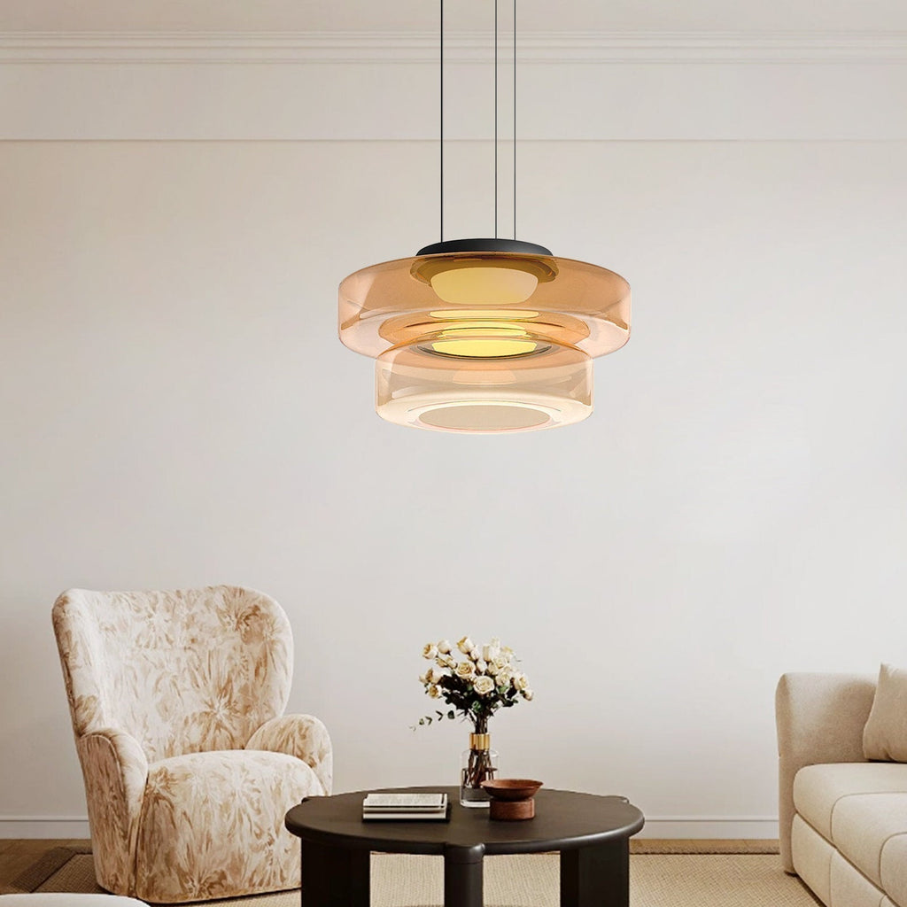 Two-tier amber Clérachic Stacked Glass Disc Pendant Light lit above a pale living room with cream armchairs and white roses.