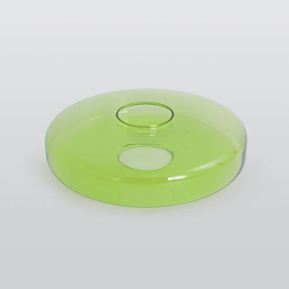 The wider green glass disc of the Clérachic Stacked Glass Disc Pendant Light seen at a low angle, its rolled rim catching light.