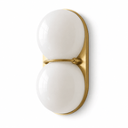 A pair of opaque white glass globes stacked on a gold-toned oval plate, shown front-on as a Clérachic wall light on white.