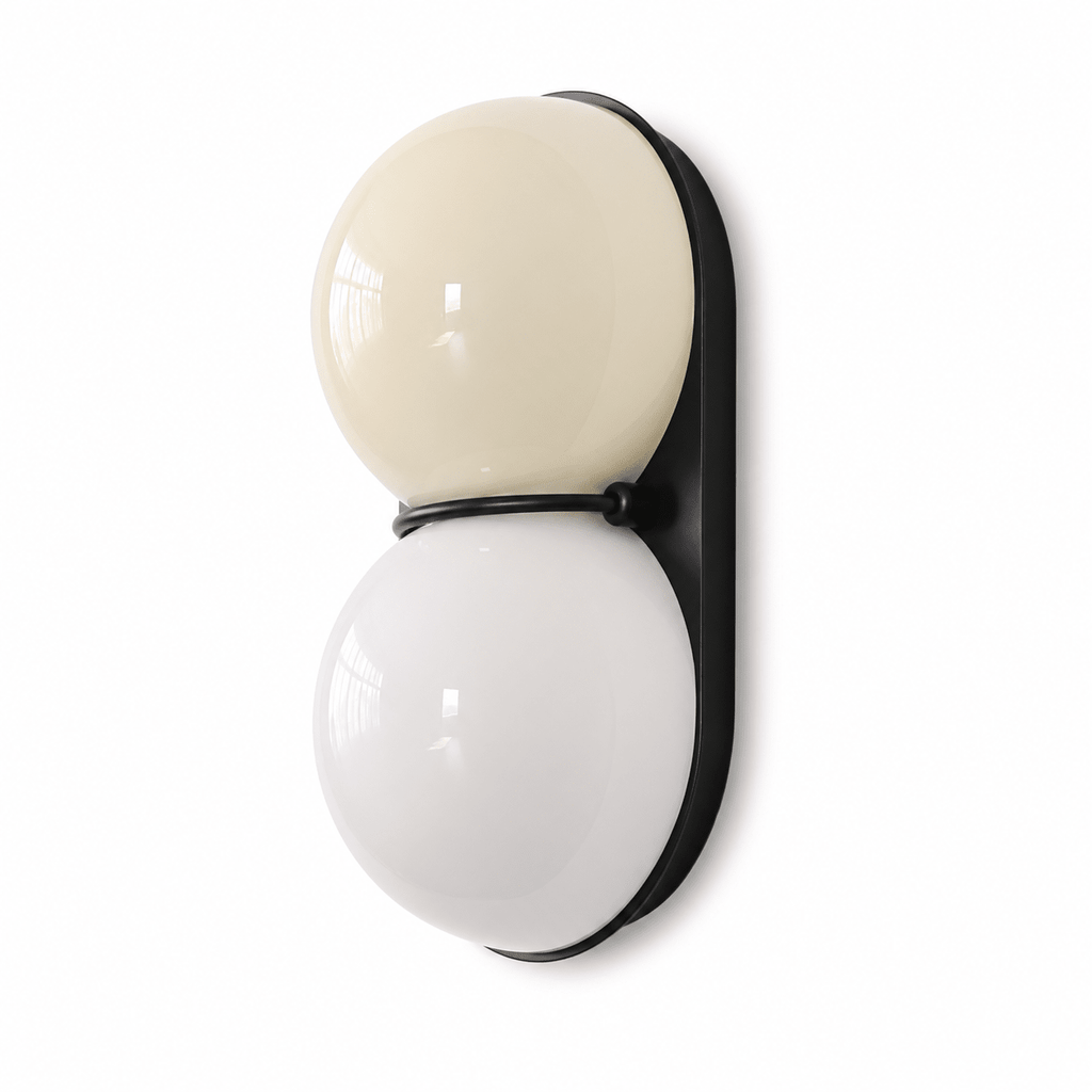 Cream upper globe over a white lower globe on a black oval backplate, this Clérachic wall light shown against plain white.