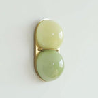 Pale lime-green over a deeper sage globe on a gold-toned plate, this Clérachic wall light shown at a slight angle.
