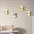 Four Clérachic wall lights step across a pale wall above a bouclé sofa and a round table with a checked mug.