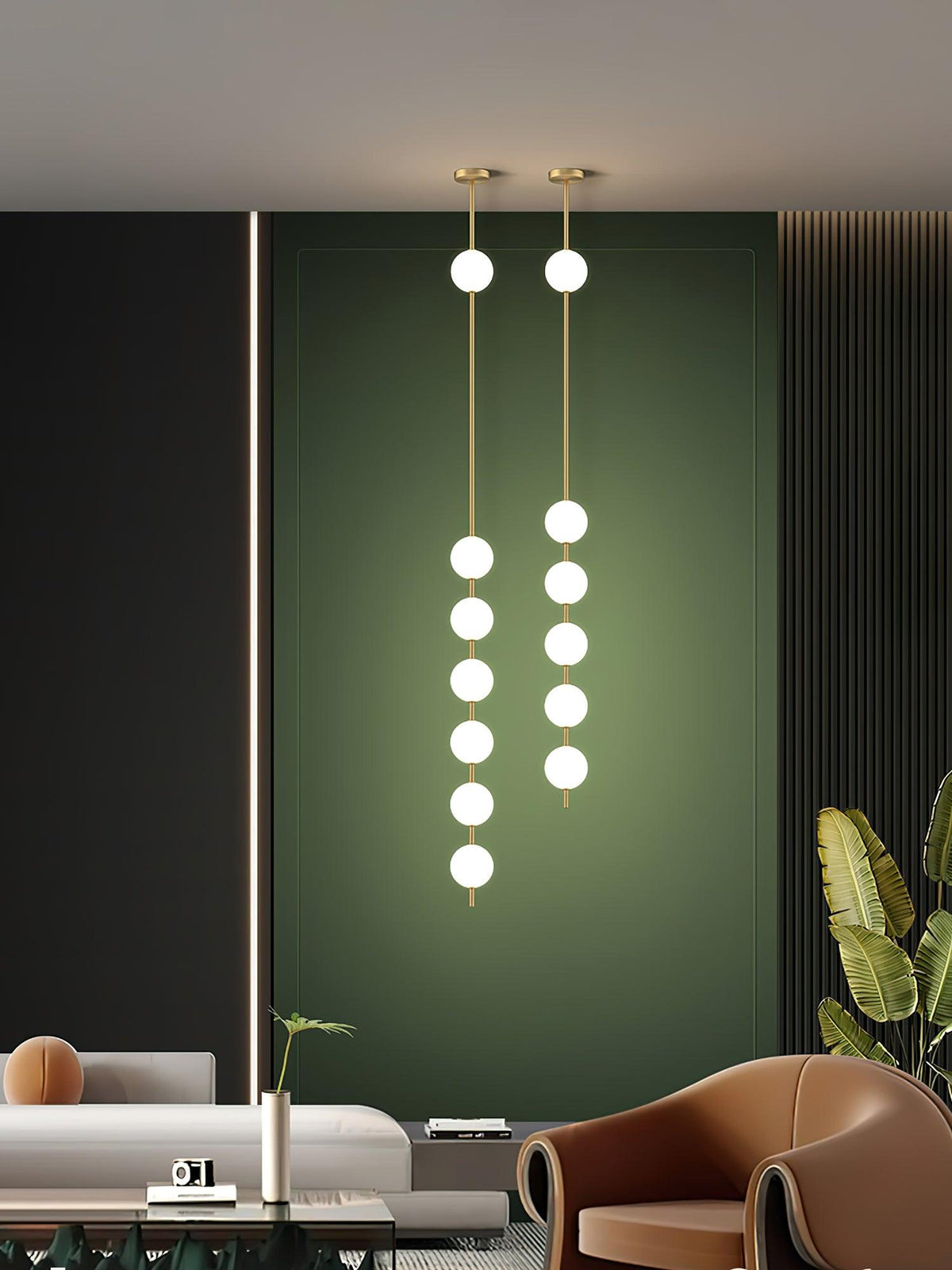 Two long Clérachic pendants lit in a dark green alcove, one with six globes and one with five, above a sofa and a tan armchair.