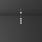 Small-scale view of a Clérachic pendant with four glowing globes on a brass column, set in a dark grey room.