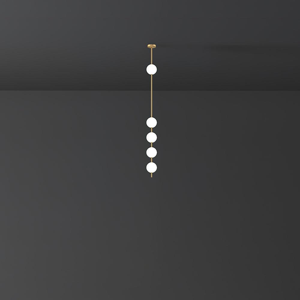 Clérachic pendant with five lit globes on a brass rod, hung small in a dark, quiet room.