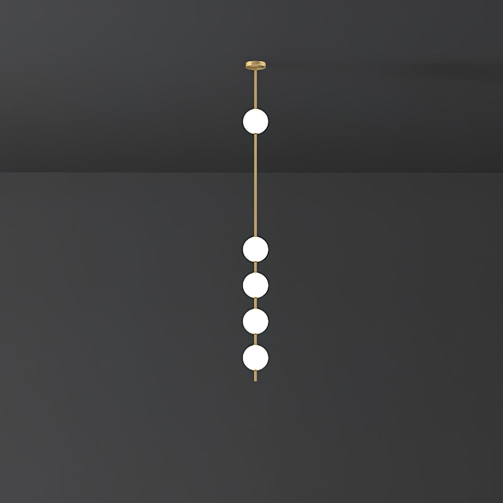 Clérachic brass-column pendant with five lit globes, larger in the frame, against a charcoal wall.