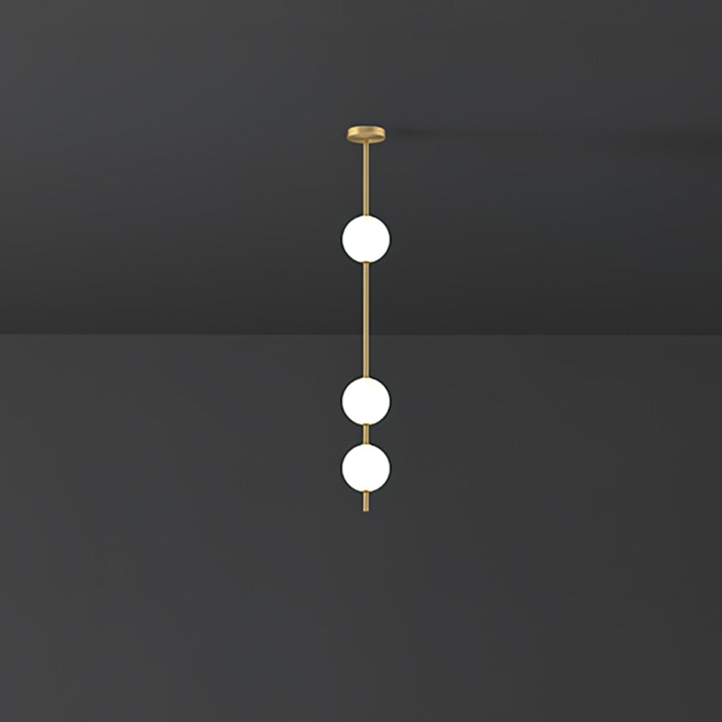 Three bright opal globes spaced along a brass rod, a short Clérachic pendant against a dark grey wall and ceiling.