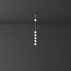 Clérachic pendant with six small opal globes in a tight group below one higher globe, against a dark grey backdrop.