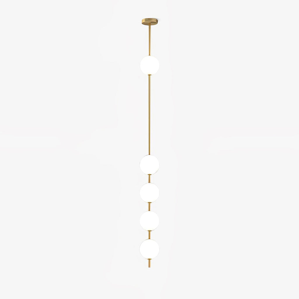 This Clérachic pendant on a pale backdrop, with five white globes down a slim brass column and a round brass ceiling plate.
