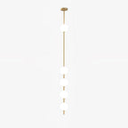 This Clérachic pendant on a pale backdrop, with five white globes down a slim brass column and a round brass ceiling plate.