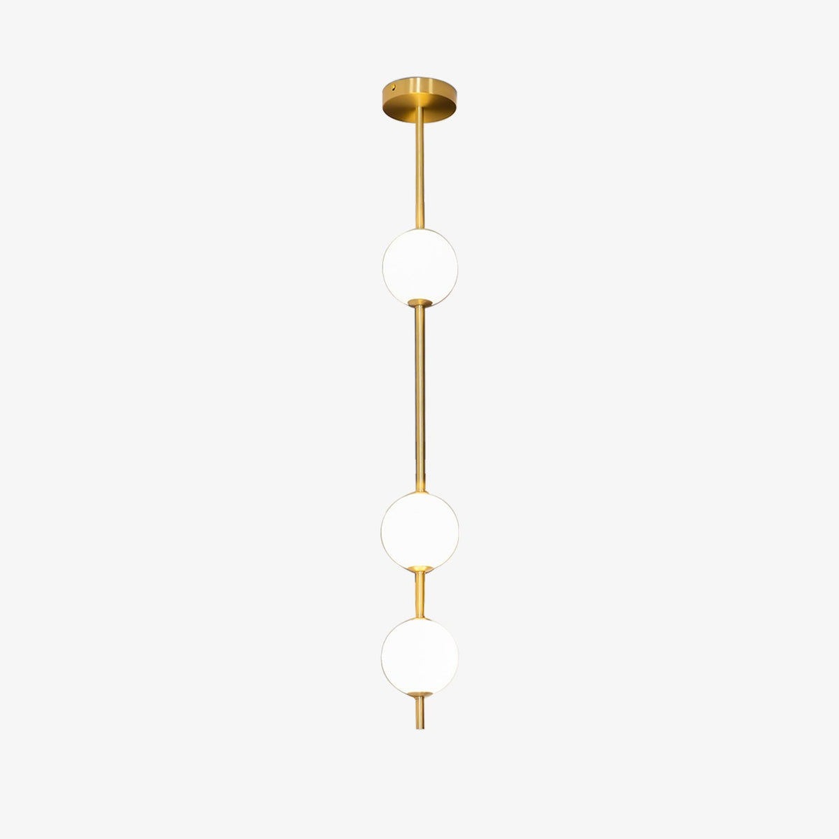 Three-globe Clérachic pendant on a pale backdrop, with a polished brass column and a domed brass ceiling plate.