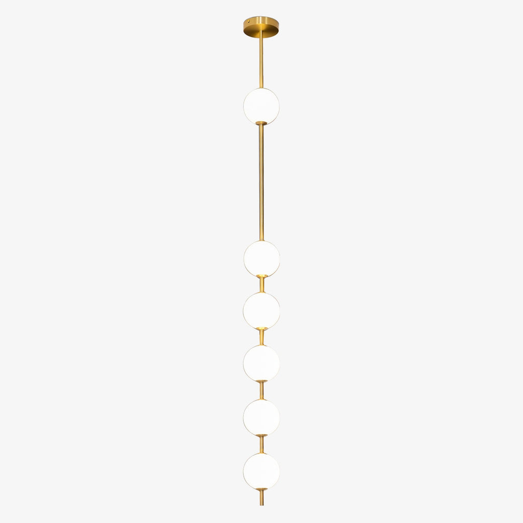 Six opal globes on a brass column from a Clérachic pendant, with a gloss brass ceiling plate on a pale grey backdrop.