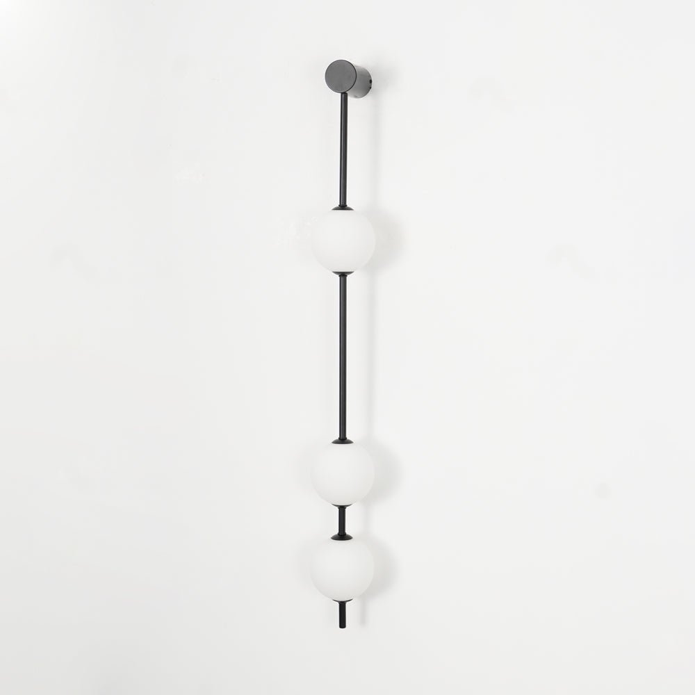 The Clérachic Stacked Globe Wall Sconce in matte black, unlit, three opal globes shown straight-on against white.