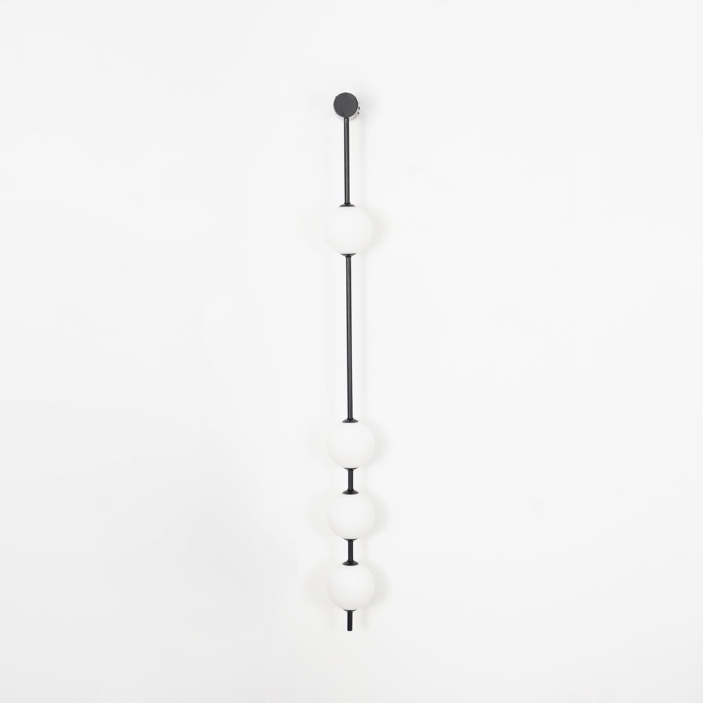 The Clérachic Stacked Globe Wall Sconce in matte black, unlit, four globes, one high and three clustered low.