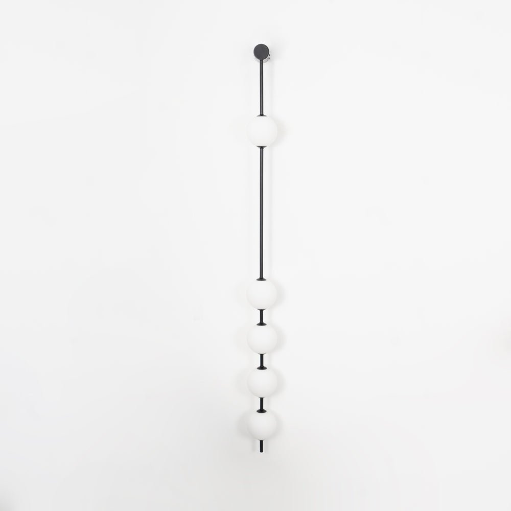 The Clérachic Stacked Globe Wall Sconce in matte black, unlit, five globes on a plain white backdrop.