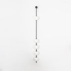 The Clérachic Stacked Globe Wall Sconce in matte black, unlit, five globes on a plain white backdrop.