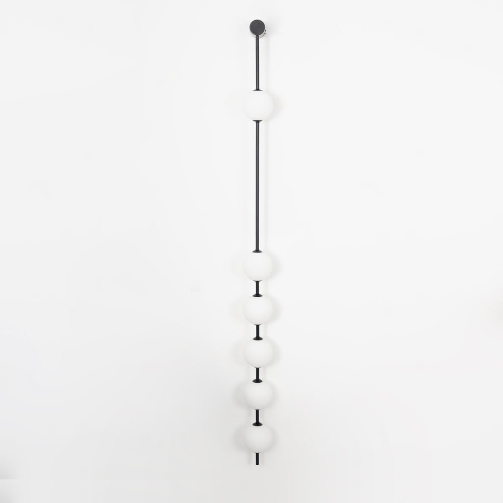 The Clérachic Stacked Globe Wall Sconce in matte black, unlit, six globes photographed flat against the wall.