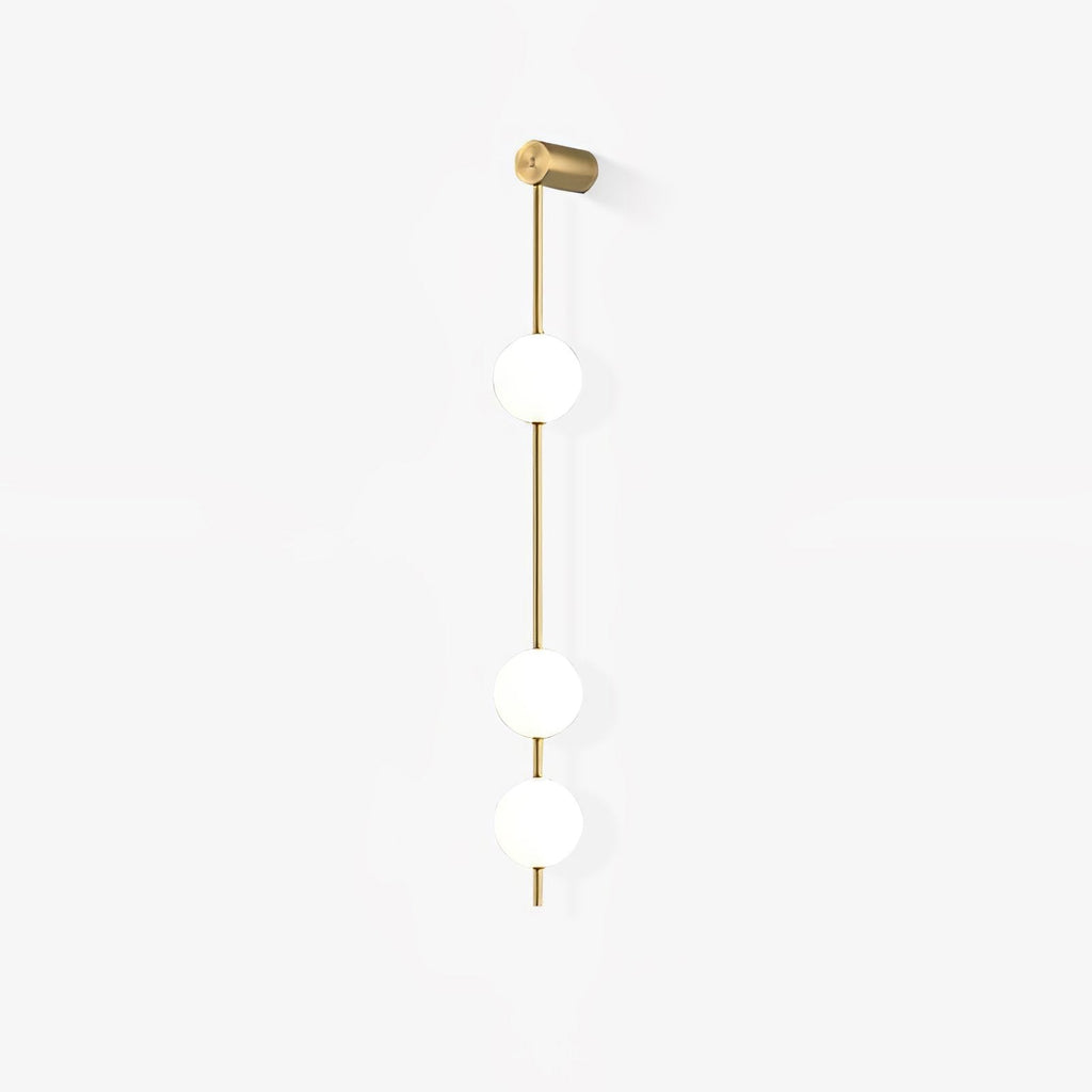 The Clérachic Stacked Globe Wall Sconce in brass, unlit, three globes photographed at a gentle angle.