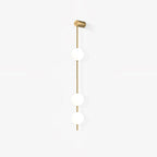 The Clérachic Stacked Globe Wall Sconce in brass, unlit, three globes photographed at a gentle angle.