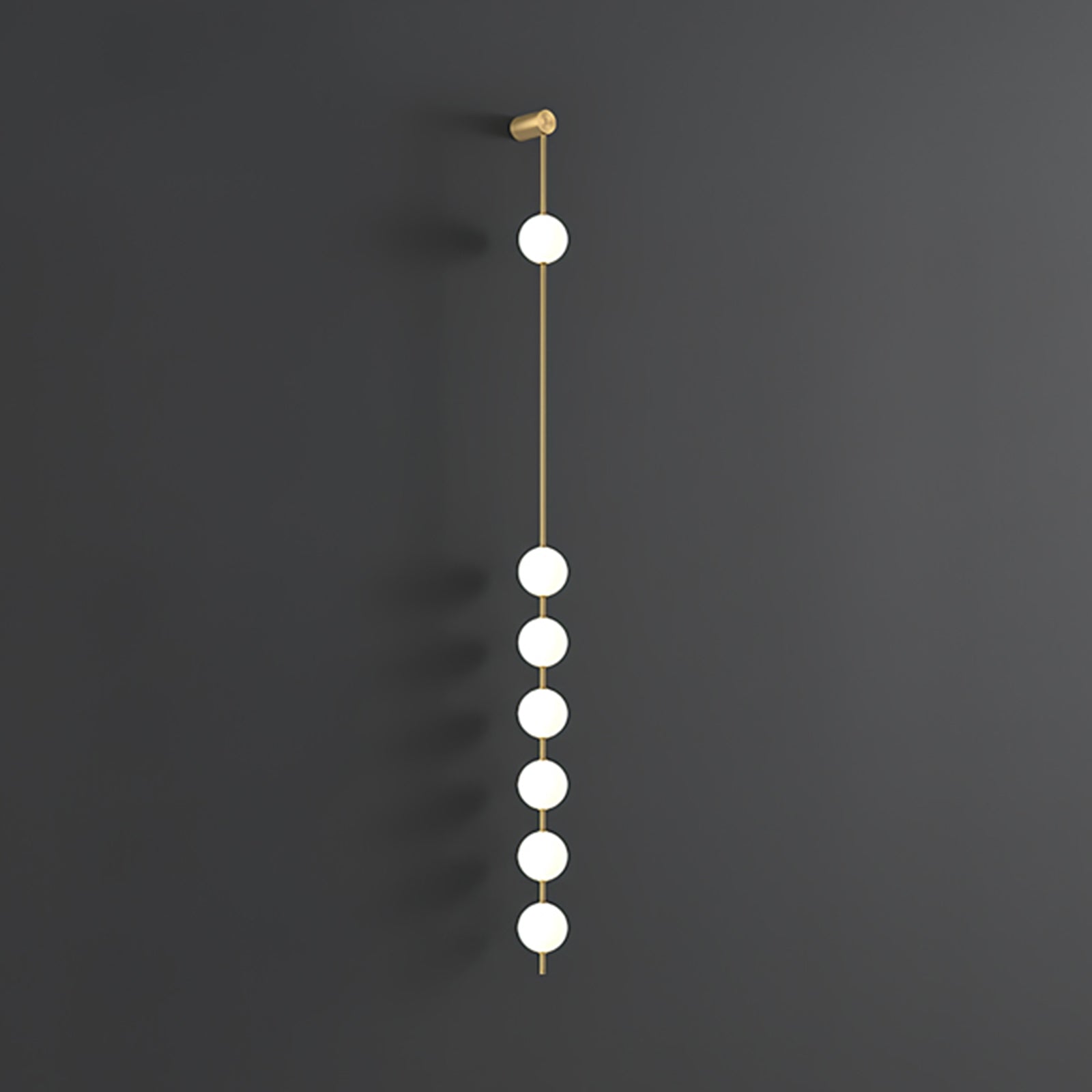 The Clérachic Stacked Globe Wall Sconce in brass, lit, six globes glowing down a dark grey backdrop.