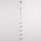 The Clérachic Stacked Globe Wall Sconce in brushed nickel, lit, six globes on a plain white backdrop.