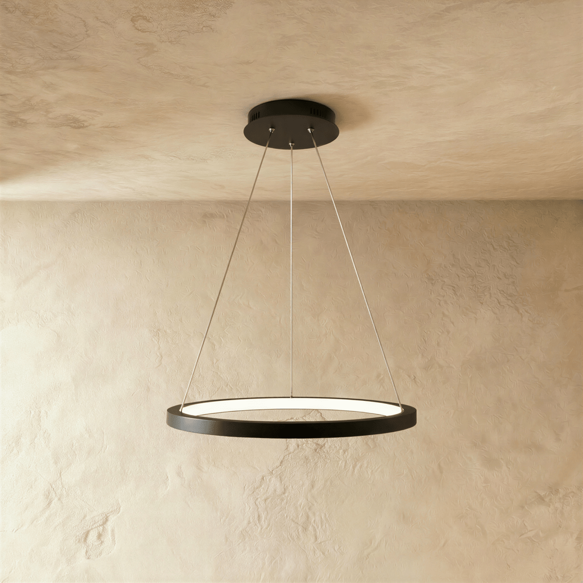 Clérachic's black ring pendant floats on slender cables, its LED edge glowing warm against a pale plaster wall.