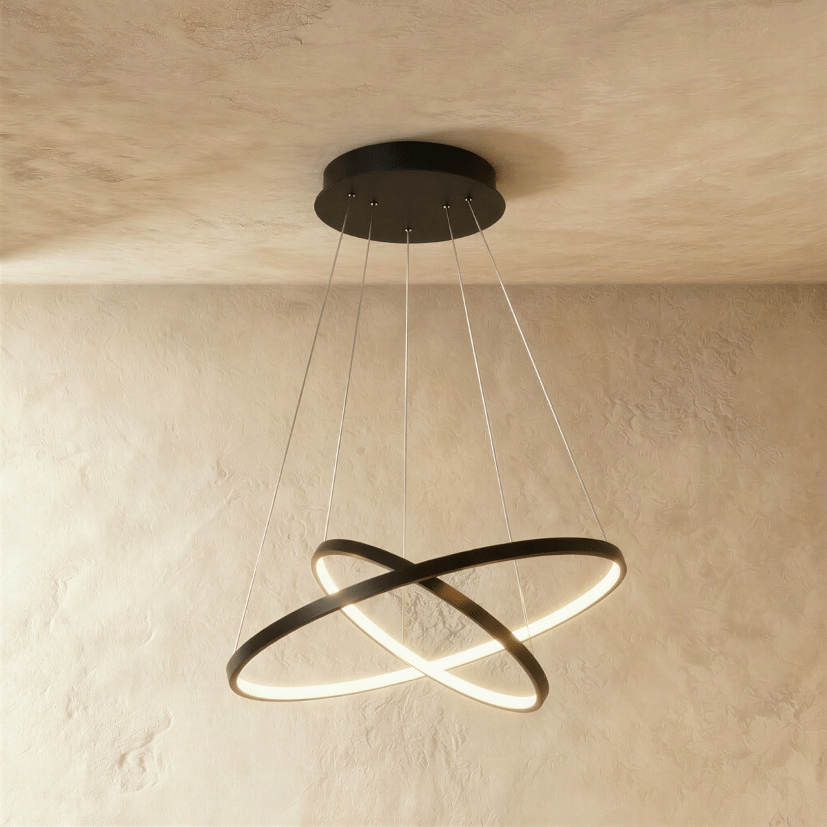 Clérachic's black two-ring chandelier shows its rings overlapping in an X, lit warm above a textured room.