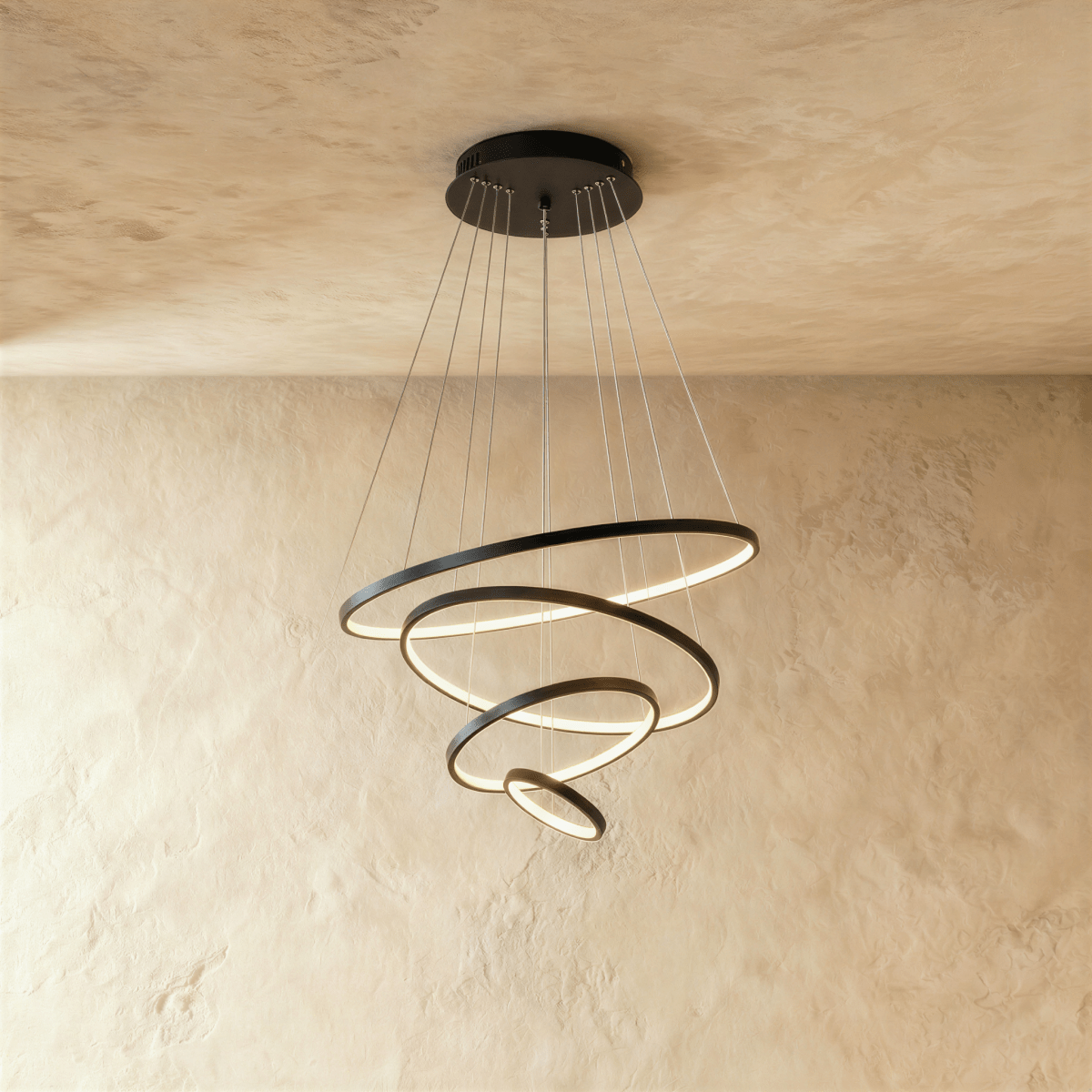 Four black rings spiral downward in this Clérachic chandelier, each ring lit warm along its inner edge.