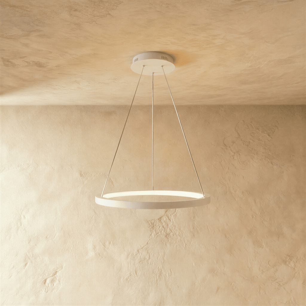 Clérachic's white ring pendant floats gently, its LED edge glowing warm against a pale plaster backdrop.