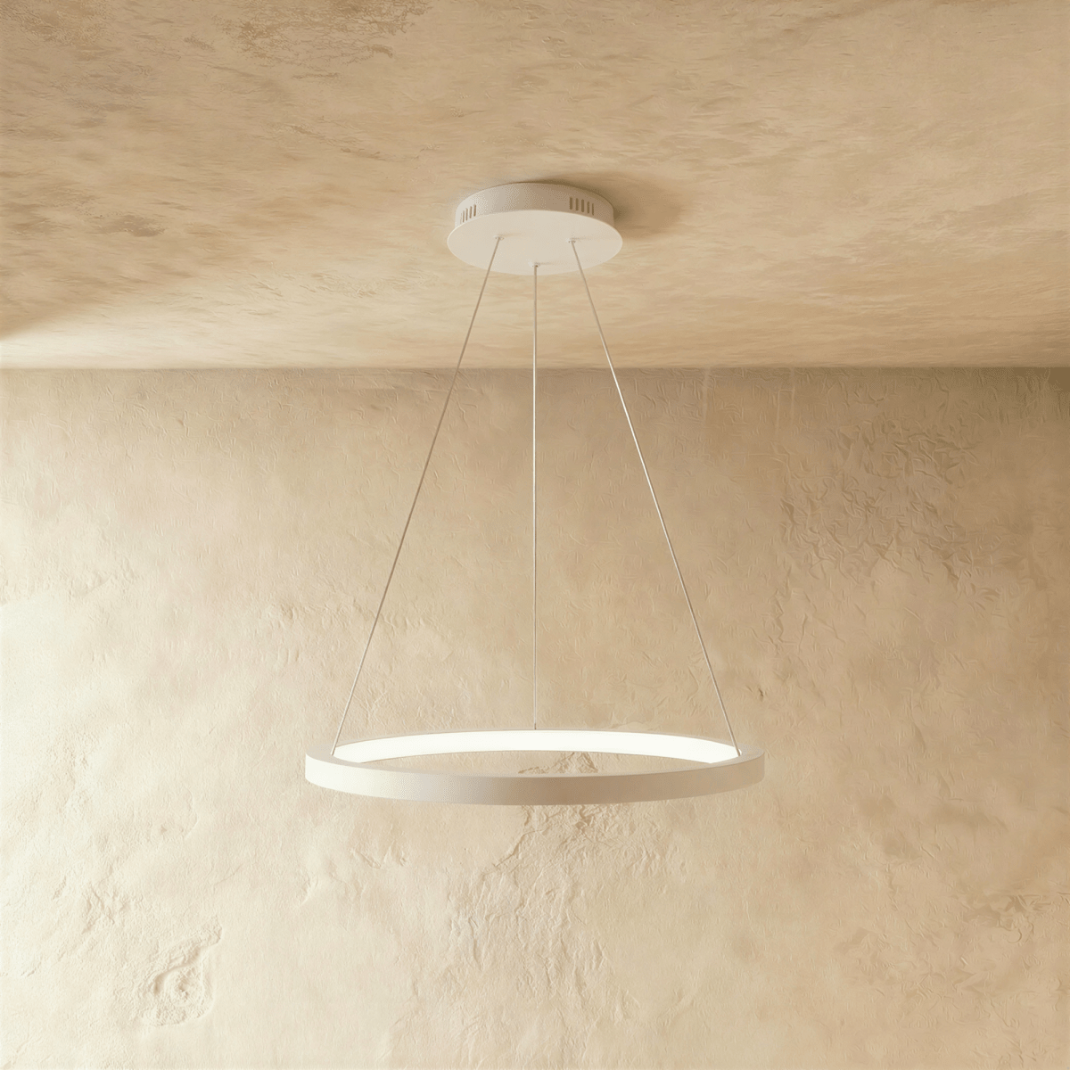 One white ring pendant from Clérachic hangs on thin cables, framed by a soft sand-toned wall and ceiling.