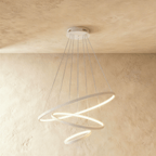 Clérachic's white three-ring chandelier spirals downward, the smallest ring glowing gently at its base.