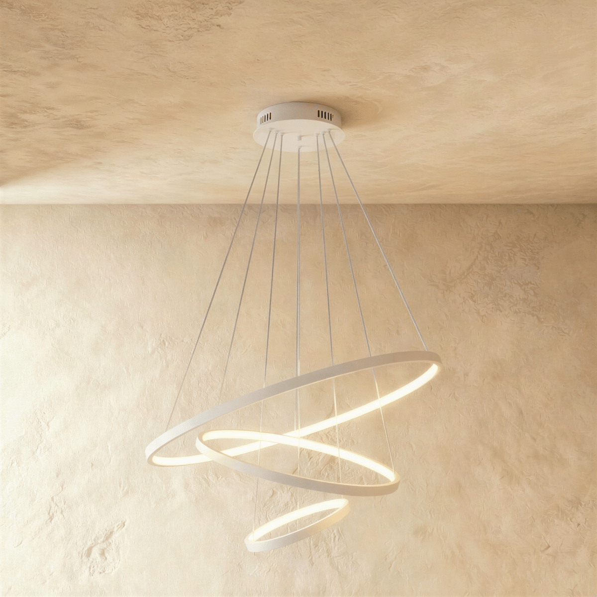 Clérachic's white three-ring chandelier spirals downward, the smallest ring glowing gently at its base.