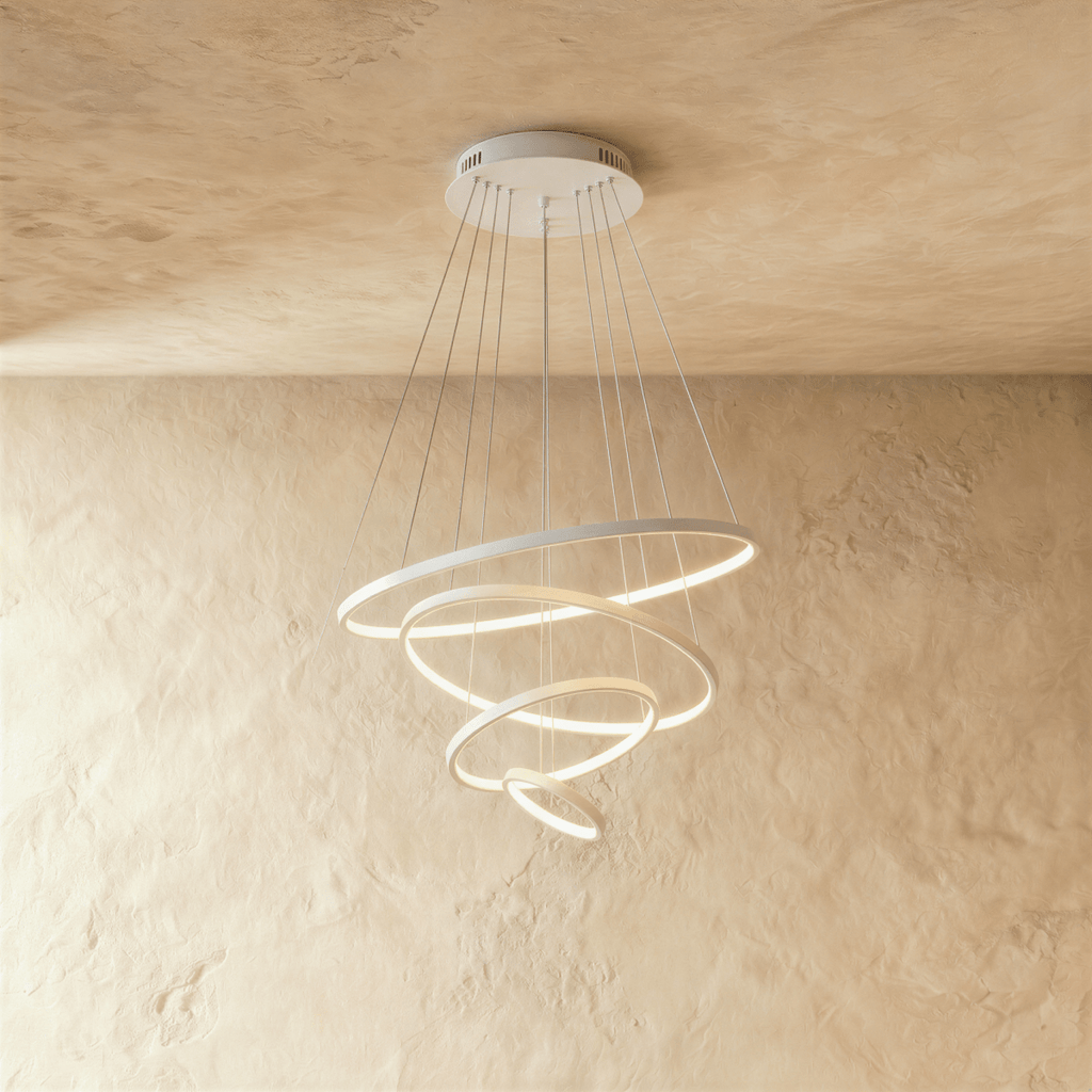 Four white rings spiral downward in this Clérachic chandelier, each ring lit warm along its inner edge.