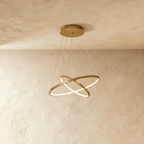 Clérachic's two-ring golden pendant crosses its rings like an X, suspended on five fine cables overhead.